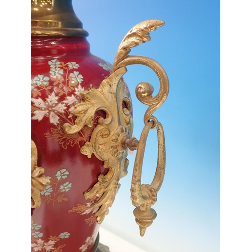 503 - A gilded metal Mantel Clock with porcelain panels of reclining cherub and floral wreath, chiming on ... 