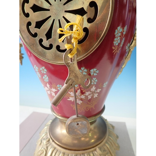 503 - A gilded metal Mantel Clock with porcelain panels of reclining cherub and floral wreath, chiming on ... 