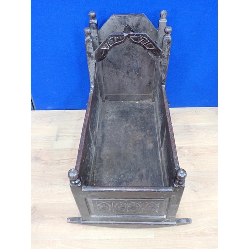 540 - An antique oak Rocking Cradle with carved panels and turned finials, possibly lacking canopy, 3ft L