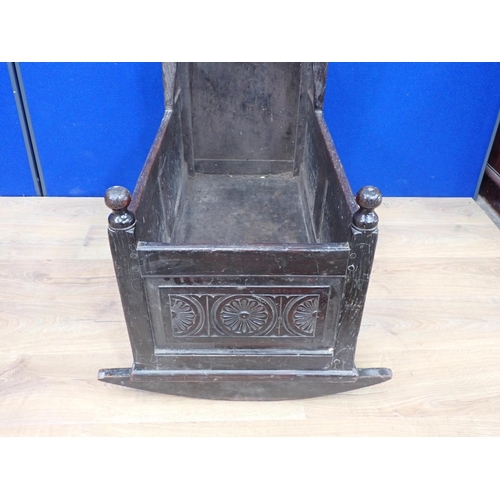 540 - An antique oak Rocking Cradle with carved panels and turned finials, possibly lacking canopy, 3ft L