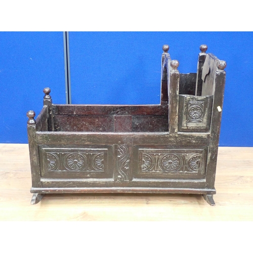 540 - An antique oak Rocking Cradle with carved panels and turned finials, possibly lacking canopy, 3ft L