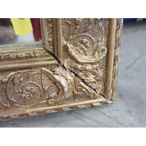 597 - A gilt framed Wall Mirror with designs of scrolls and foliate detail, 2ft 6in x 1ft 11in