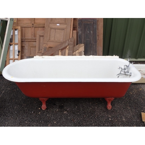 621 - A heavy cast iron roll top iron Bath with cast ball and claw supports, some scratching and rubbing i... 