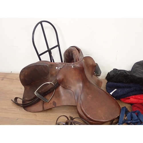 75 - A leather Saddle, metal Rack, Bridle, Leading Rein and Horse Blankets etc