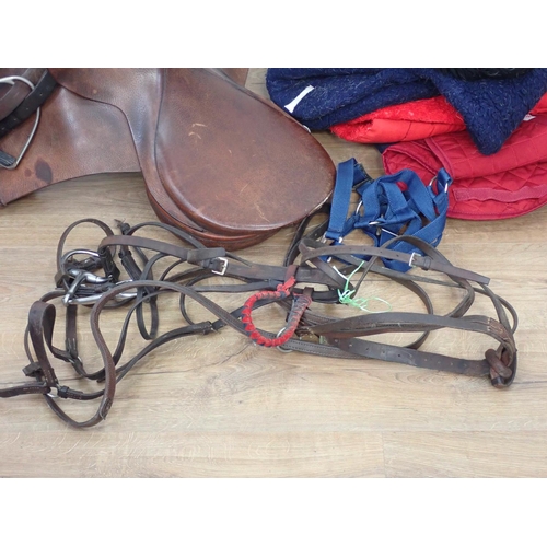 75 - A leather Saddle, metal Rack, Bridle, Leading Rein and Horse Blankets etc