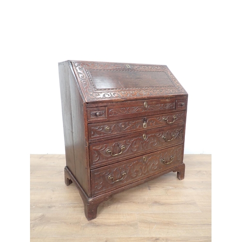 77 - A Carved oak Bureau with fitted interior including a well above three long graduated drawers, 3ft W