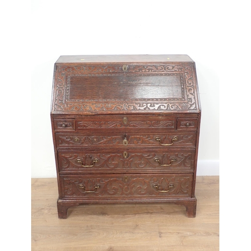 77 - A Carved oak Bureau with fitted interior including a well above three long graduated drawers, 3ft W