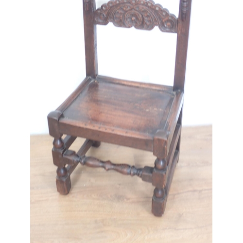 94 - An antique oak Derbyshire single chair with carving to the back, solid seat, turned and squared supp... 