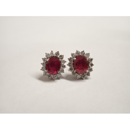 153 - A pair of Ruby and diamond Cluster Earrings each claw-set oval-cut ruby, estimated total ruby weight... 