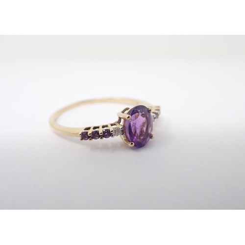 159 - An Amethyst and Diamond ring claw-set oval-cut amethyst between two brilliant-cut diamonds and trios... 