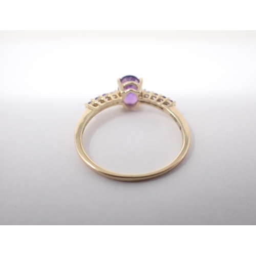 159 - An Amethyst and Diamond ring claw-set oval-cut amethyst between two brilliant-cut diamonds and trios... 