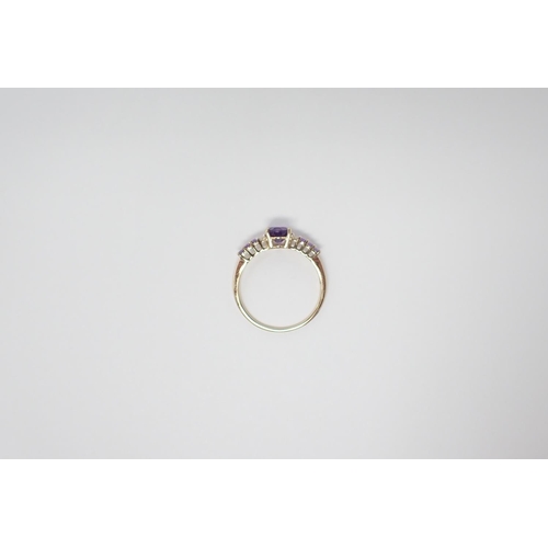 159 - An Amethyst and Diamond ring claw-set oval-cut amethyst between two brilliant-cut diamonds and trios... 