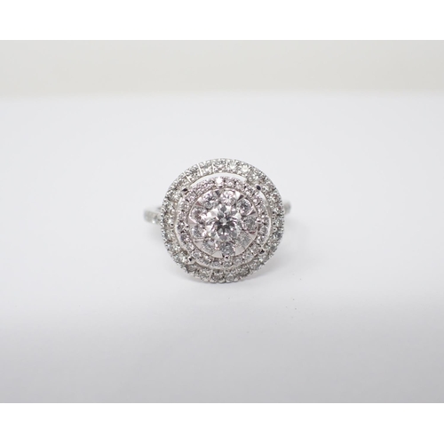 172 - A Diamond Halo Cluster Ring the principle brilliant-cut stone set within eight smaller stones and tw... 