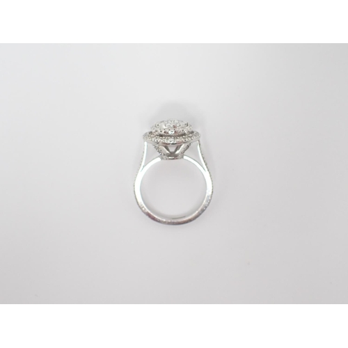 172 - A Diamond Halo Cluster Ring the principle brilliant-cut stone set within eight smaller stones and tw... 