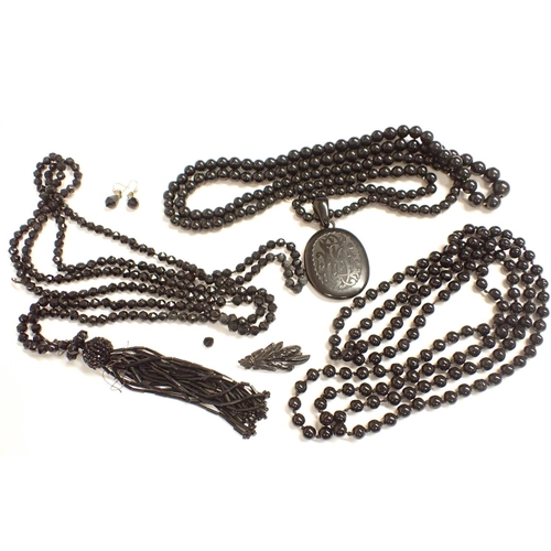 195 - A Jet bead Necklace with oval pendant carved monogram and shamrock, a long string of black glass Bea... 