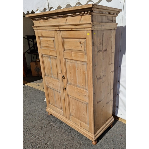 33 - An antique pine two door Wardrobe with dentil carved cornice mounted upon turned feet 5ft 9in H x 4f... 