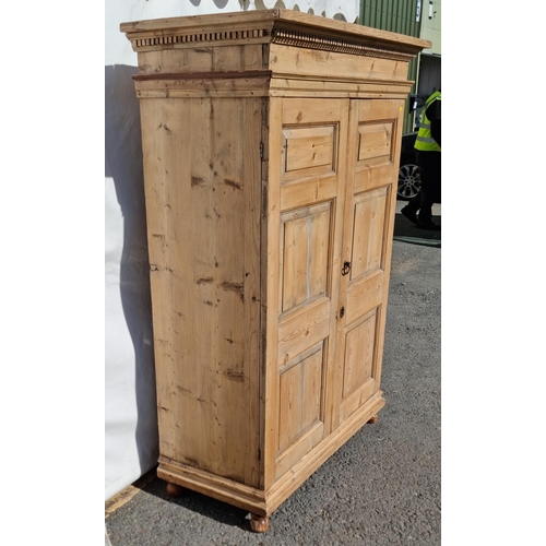 33 - An antique pine two door Wardrobe with dentil carved cornice mounted upon turned feet 5ft 9in H x 4f... 