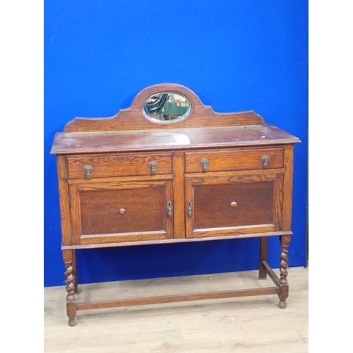 334 - A 1920's oak Sideboard with oval mirror back fitted two frieze drawers above pair of cupboard doors ... 