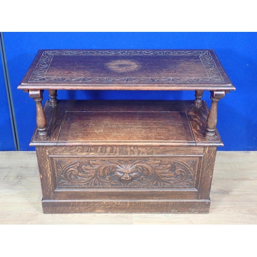 501 - An early 20th Century oak Monk's Bench with mask and leafage carved front panel 2ft 11in W x 2ft 5in... 