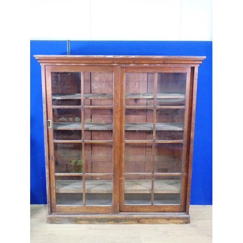 551 - An antique oak and mixed wood Bookcase fitted with two sliding glazed doors enclosing adjustable she... 