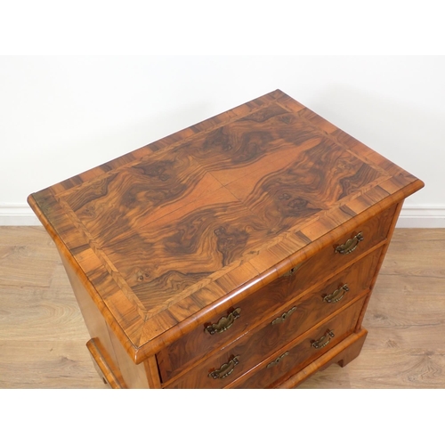 580 - A reproduction walnut Chest of small proportions with quartered moulded top fitted three drawers on ... 