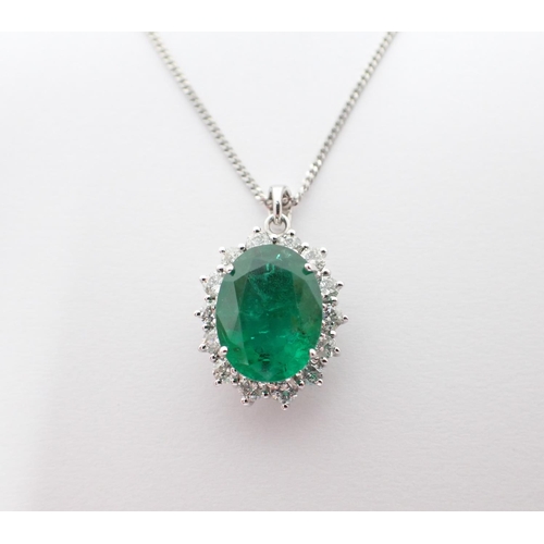 109 - An Emerald and Diamond Cluster Pendant claw-set oval-cut emerald, 3.27cts, within a frame of brillia... 