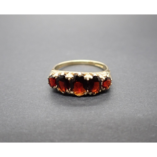 121 - A Garnet five stone Ring claw-set graduated oval-cut stones in 9ct gold, ring size N