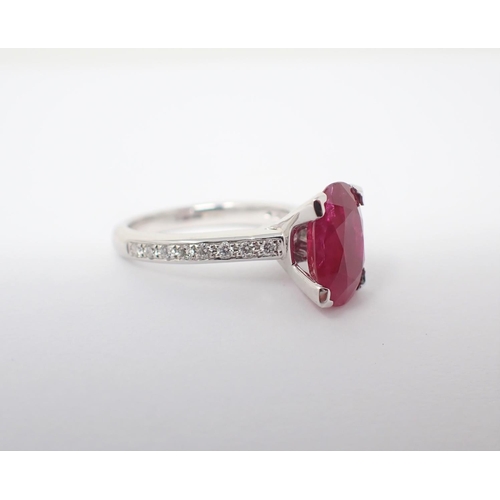 127 - A Ruby and Diamond Ring claw-set oval-cut ruby, 2.15cts, between pavé-set brilliant-cut diamonds to ... 