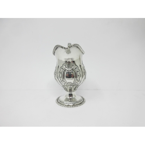 14 - An Edward VII silver helmet shape Cream Jug with floral embossing on pedestal base, Chester 1905