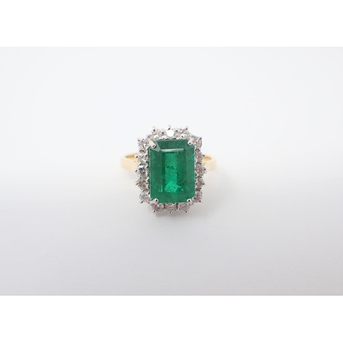 152 - An Emerald and Diamond Cluster Ring corner claw-set step-cut emerald, 3.80cts, within a frame of cla... 