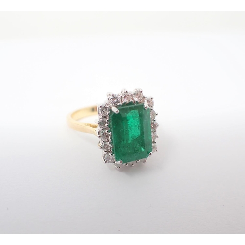 152 - An Emerald and Diamond Cluster Ring corner claw-set step-cut emerald, 3.80cts, within a frame of cla... 