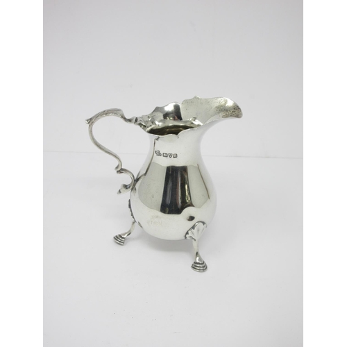 17 - A George V silver Cream Jug with shaped rim on hoof feet, Chester 1930