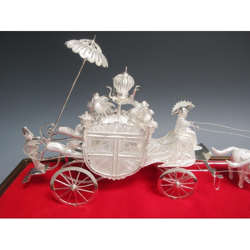 26 - An Indonesian filigree silver four wheel Carriage and team of Horses, 24in, under glass dome, in tra... 