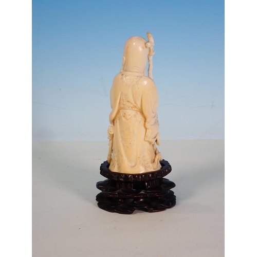 273 - An early 20th Century ivory Figure of a sage holding a staff with pierced and engraved detail on a c... 