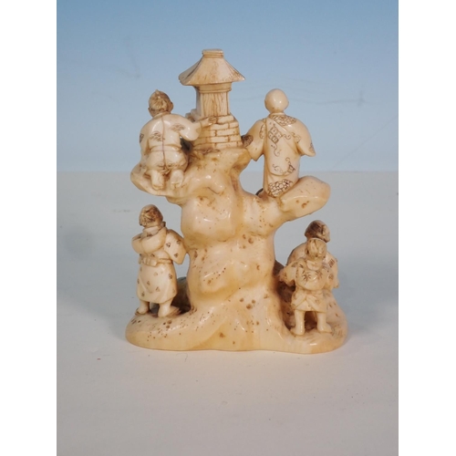 275 - An early 20th Century Japanese ivory Figure Group of six figures stood or climbing a tree stump, 4in... 