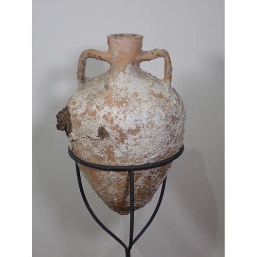 291 - A terracotta Roman Amphora Vase with marine encrustations, 22in high on metal stand