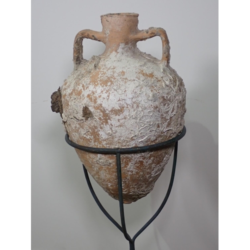 291 - A terracotta Roman Amphora Vase with marine encrustations, 22in high on metal stand