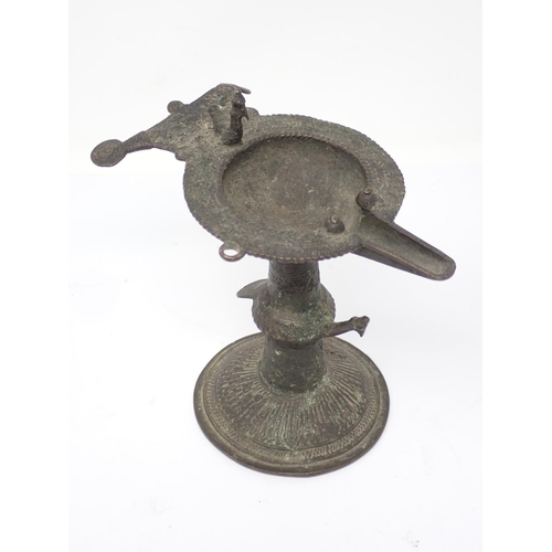 317 - An antique Indian bronze Orissa Oil Lamp with bird finial on circular base 6 1/4in H