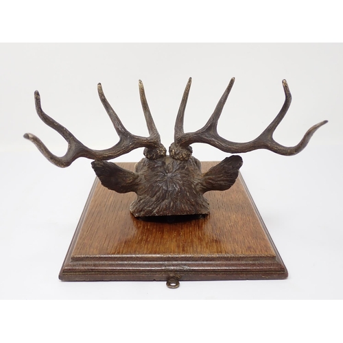 339 - An Austrian cold painted bronze Paper/Letter Clip in the form of a Stags Head mounted on an oak plaq... 