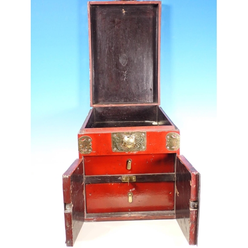 379 - A red lacquered Korean Travelling Box with decorative pierced and engraved brass fitting, having hin... 