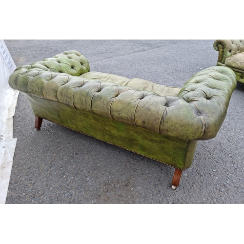 391 - A green leather button upholstered Chesterfield Settee on turned walnut front supports and casters, ... 