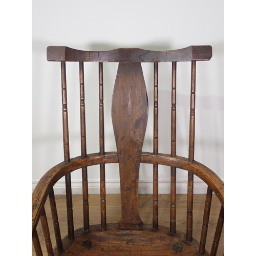 401 - A primitive Windsor Armchair in elm, oak etc with shaped solid splat and turned spindles, dished sea... 