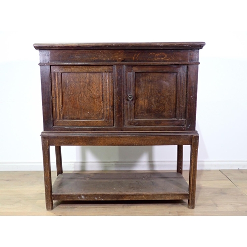 411 - A 17th Century oak Food Cupboard the pair of panelled doors with pierced arched and lozenge designs ... 