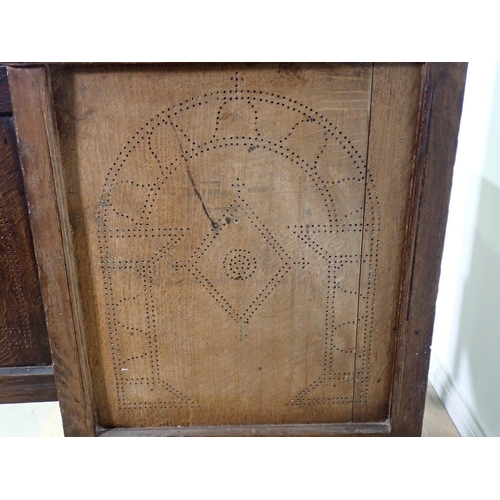 411 - A 17th Century oak Food Cupboard the pair of panelled doors with pierced arched and lozenge designs ... 