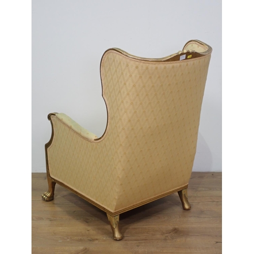 436 - A gilt framed winged Occasional Chair with carved top rail, yellow upholstery and cushion on carved ... 