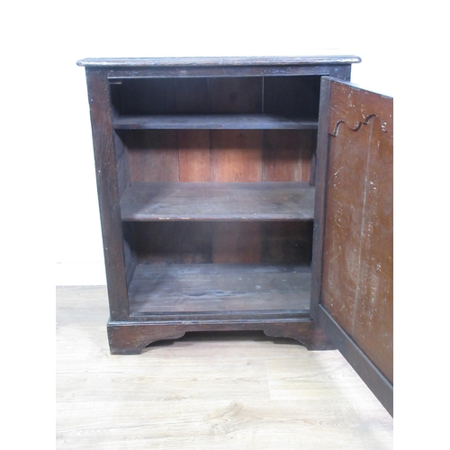 446 - An antique oak Cupboard, the single door with fielded panel enclosing a shelf and panelled to the si... 