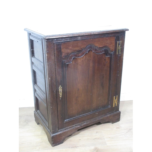 446 - An antique oak Cupboard, the single door with fielded panel enclosing a shelf and panelled to the si... 