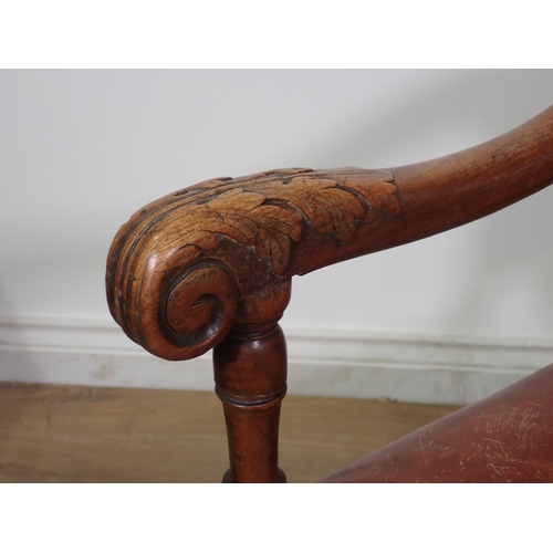 451 - A 19th Century carved Elbow Chair with leather upholstered back and seat, acanthus leaf carving to t... 