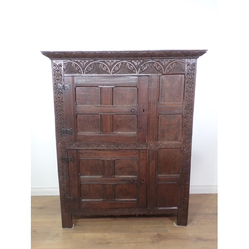 453 - A 17th Century and later oak ventilated Food Cupboard with carved cornice and frieze, two panelled c... 