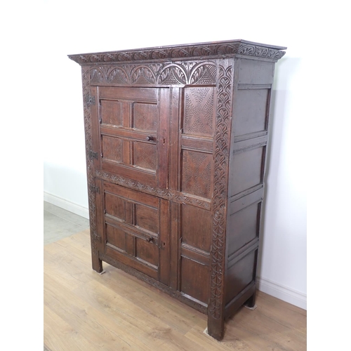 453 - A 17th Century and later oak ventilated Food Cupboard with carved cornice and frieze, two panelled c... 